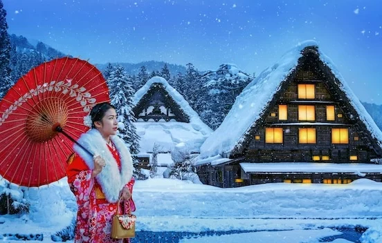 Woman in traditional Japanese winter kimono with red umbrella at snow-covered Shirakawa-go village, wearing furisode with white fur collar against traditional gassho-zukuri farmhouses