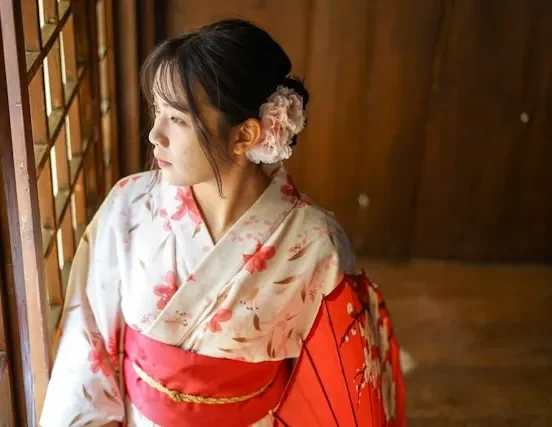 Traditional Japanese kimono with intricately tied gold obi sash and cherry blossom patterns, showcasing authentic wafuku craftsmanship