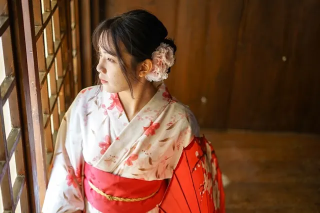 Traditional Japanese kimono with intricately tied gold obi sash and cherry blossom patterns, showcasing authentic wafuku craftsmanship