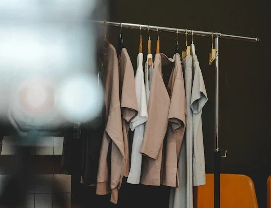 Minimalist capsule wardrobe essentials hanging on modern rack in neutral colors