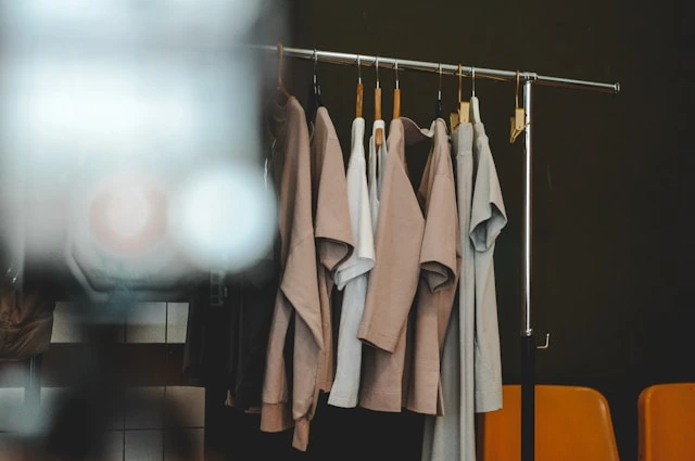 Minimalist capsule wardrobe essentials hanging on modern rack in neutral colors