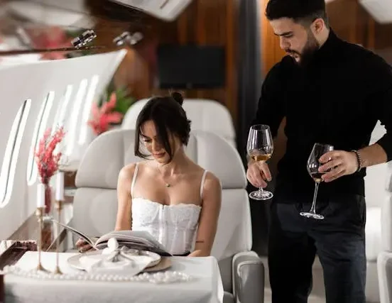 Elegant couple enjoying luxury private jet cabin with champagne and in-flight dining experience