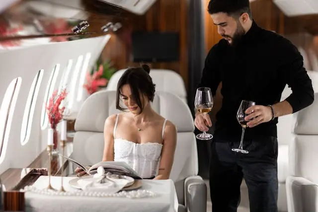 Elegant couple enjoying luxury private jet cabin with champagne and in-flight dining experience